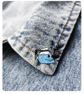 Enamel pin of skull coffee pot on blue denim jacket collar with intricate details