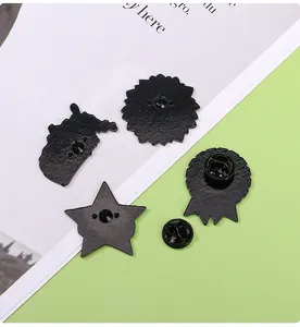 Detail view of four black alloy lapel pin backs with textured finish and rubber clutches