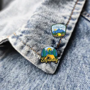 Cartoon enamel pins with wilderness and exploring motifs on a denim jacket background