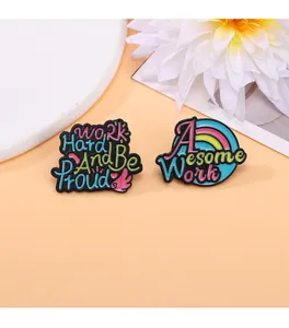 Detailed view of two inspirational enamel pins with Work Hard and Awesome Work slogans