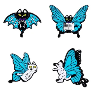 Set di quattro spille gatto in smalto con ali di farfalla e testo Cat Happy blu e nero