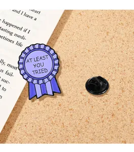 Détail de la broche médaille en émail violet avec texte et fermoir papillon en métal au dos