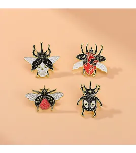 Detailed close-up of four gothic enamel insect pins with skull, heart and brain motifs