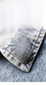 Détail du pin's émaillé jaune en forme de cœur avec texte sur tissu en denim bleu