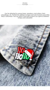 Dettaglio della spilla smaltata natalizia Ho Ho Ho su una giacca di jeans blu