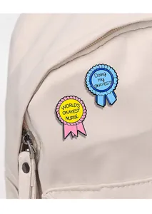 Gros plan de pin's en émail sur un sac en toile montrant des textes d'humour