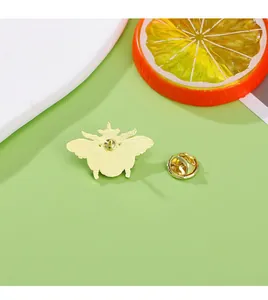 Detailed back view of a gold bee enamel pin with secure butterfly clutch and metal texture