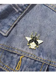 Enamel beetle skull pin with starry sky pattern shown on a blue denim jacket