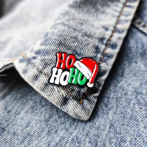 Spilla natalizia smaltata HO HO HO con cappello di Babbo Natale su colletto di jeans