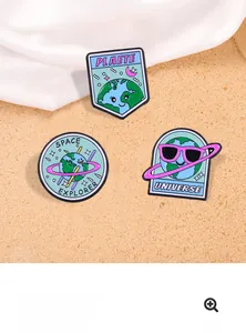 Close-up of space themed enamel pins showing colorful planet and universe explorer designs