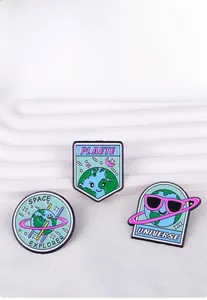 Detailed view of three cute enamel planet pins with Space Explorer and Universe text