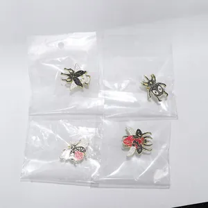 Detail view of insect enamel pins with heart and skull motifs in clear OPP packaging