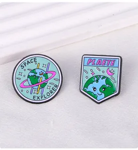 Detailed macro of enamel space explorer pins with planet motifs on white background