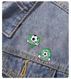 Dettaglio delle spille da calcio in smalto su sfondo di tessuto denim blu