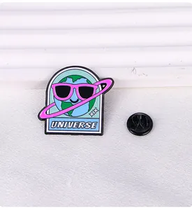 Detailed close-up of a cute blue earth enamel pin with pink sunglasses and star details