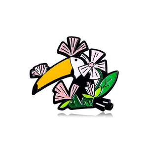 Broche en émail mignonne toucan avec bec jaune et fleurs colorées sur fond blanc
