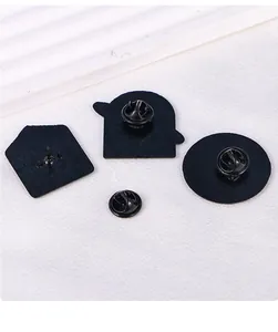 Detail view of durable black metal pins with butterfly clutch backings on white textured fabric