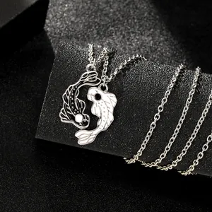 Macro shot of Yin Yang koi fish pendants in black and white enamel on silver chains