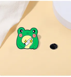 Detail of cute green frog enamel pin holding a small knife with glittery star effects