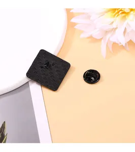 Detailed back view of square metal pin showing black textured finish and rubber clutch
