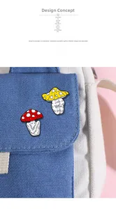 Close-up of red and yellow mushroom pins attached to a blue canvas bag as decoration