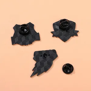 Set di tre spille da calcio in metallo nero con retro testurizzato e chiusure in gomma