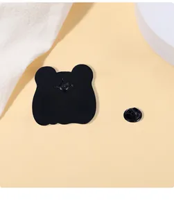 Macro detail of the bear-shaped black enamel brooch back with butterfly clutch pin fastener