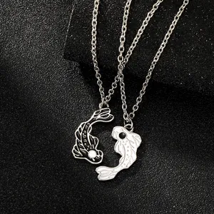 Macro shot of yin yang koi fish necklaces for couples with polished silver chains