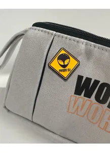 Close-up of Area 51 alien badge on grey canvas pencil case with high texture detail