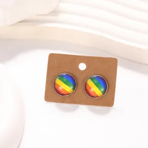 Gros plan de boucles d'oreilles arc-en-ciel rondes argentées sur support en carton