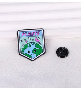 Detailed close-up of cute cartoon earth enamel pin with planet text and butterfly clutch