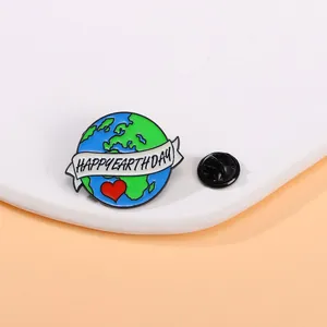 Detail of Happy Earth Day enamel pin with rubber clutch on a white stone background
