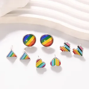 Détail de boucles d'oreilles émaillées arc-en-ciel en formes de cœur et géométriques