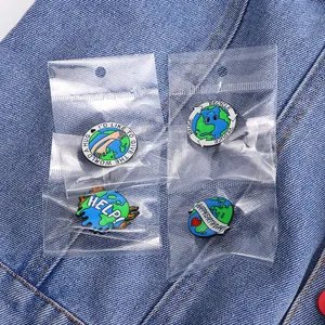 Set of four eco-friendly enamel pins with Earth Day slogans on a denim background