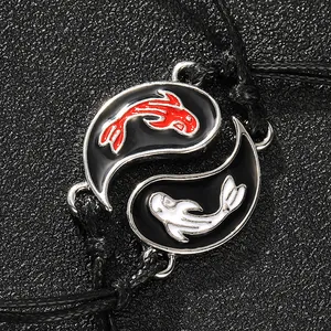 Macro detail of Yin Yang koi fish pendants on adjustable black braided bracelets