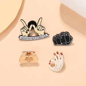 Detailed view of four creative enamel pins with whatever forever and empower slogans