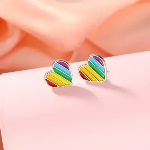 Gros plan sur des boucles d'oreilles cœur en émail arc-en-ciel avec finition métal argenté