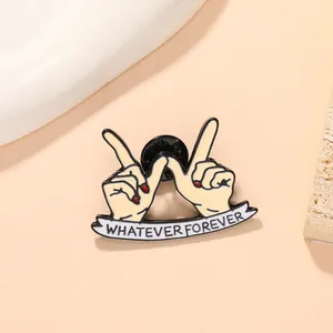 Close-up of enamel hand gesture brooch with red nails and Whatever Forever banner
