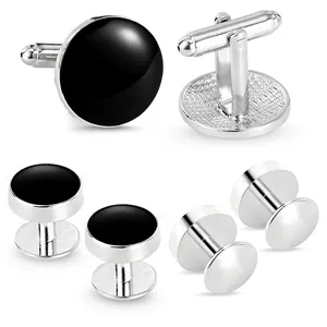 Silver cufflinks and tuxedo studs set with round black enamel inlay on white background