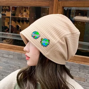 Beige ribbed knit beanie with Happy Earth Day and Help melting earth enamel pins