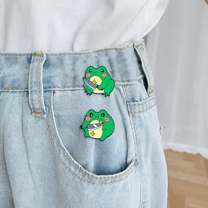 Funny cartoon frog enamel pin set with knife on denim pocket of a white T-shirt