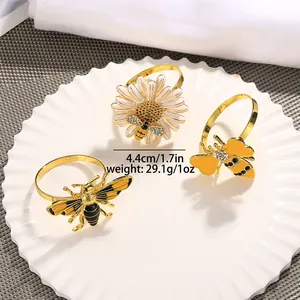 Detalle de servilleteros de abeja y margarita en aleación con esmalte y pedrería