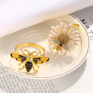 Detalle de los servilleteros de abeja y margarita sobre un elegante plato cerámico
