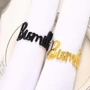 Détail des ronds de serviette Bismillah en métal doré et noir sur tissu blanc