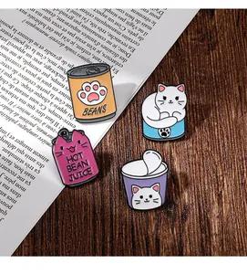 Lot de pins émaillés chat de dessin animé dans des boîtes sur une table en bois