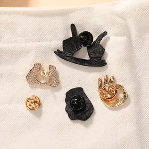 Creative hand gesture enamel pins in black and gold finish with butterfly clutch backings