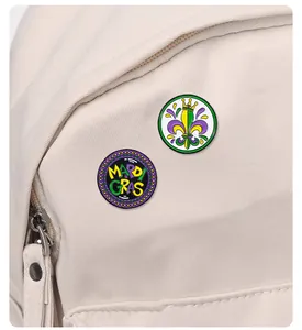 Detalle de dos pines esmaltados de Mardi Gras con corona y letras sobre bolso de lona