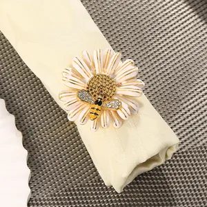 Detalle del servilletero de margarita con pequeña abeja y brillantes sobre servilleta