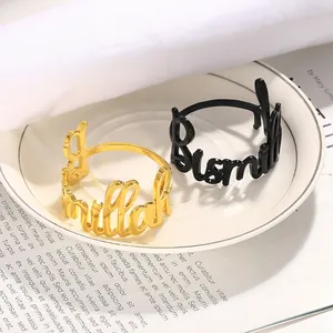 Gros plan de ronds de serviette évidés Bismillah en or et noir pour table chic