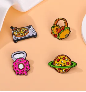 Détail de quatre broches en émail créatives avec des motifs de dessins animés de nourriture